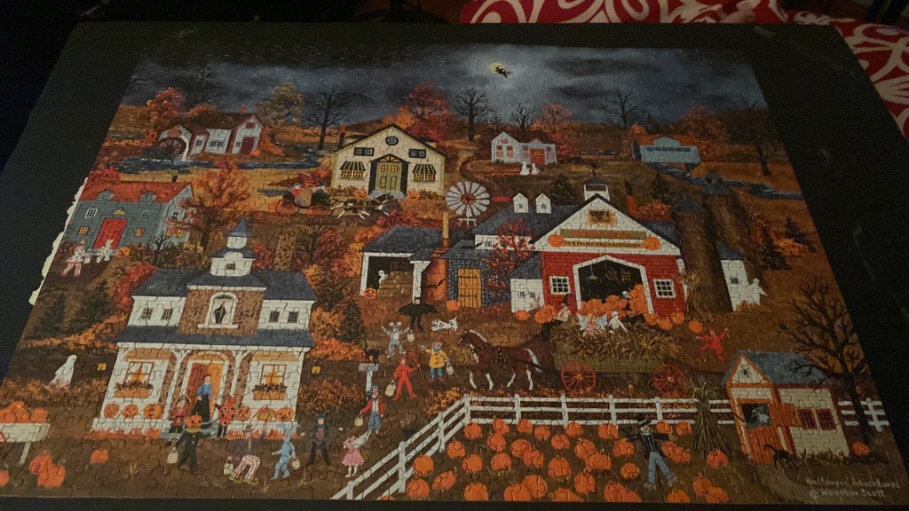A whimsical folk-art style illustration of a Halloween village scene at night with children in costumes and pumpkins.