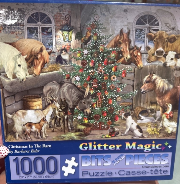 A cozy barn scene at Christmas filled with various farm animals surrounding a decorated Christmas tree.