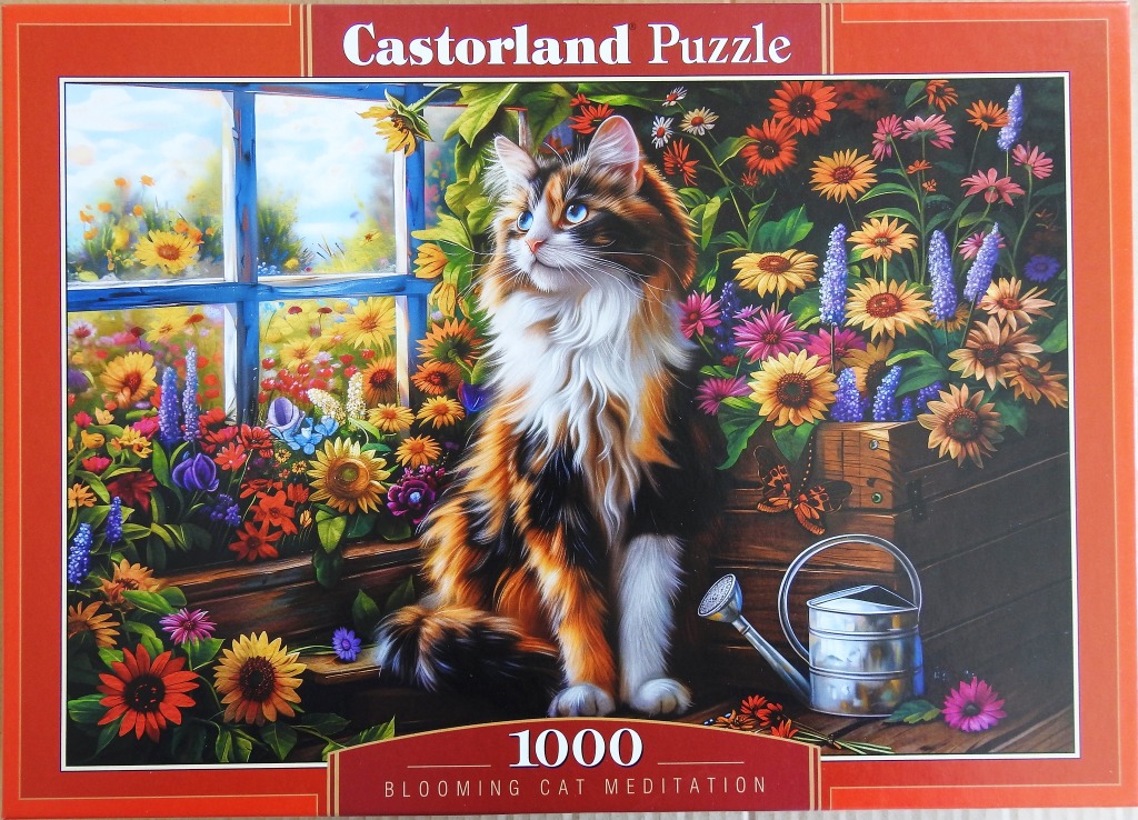 A long-haired tortoiseshell calico cat sits near a window in a lush garden filled with colourful summer flowers.