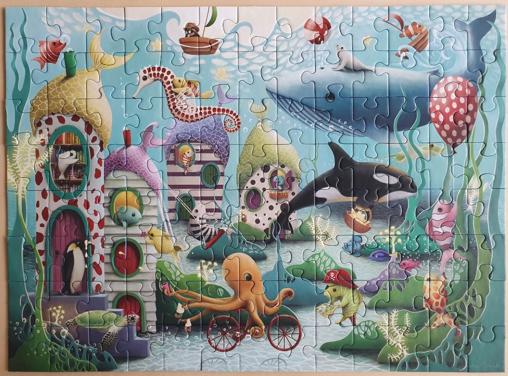 Whimsical underwater illustration featuring a colorful sea-creature town with an octopus on a bicycle.