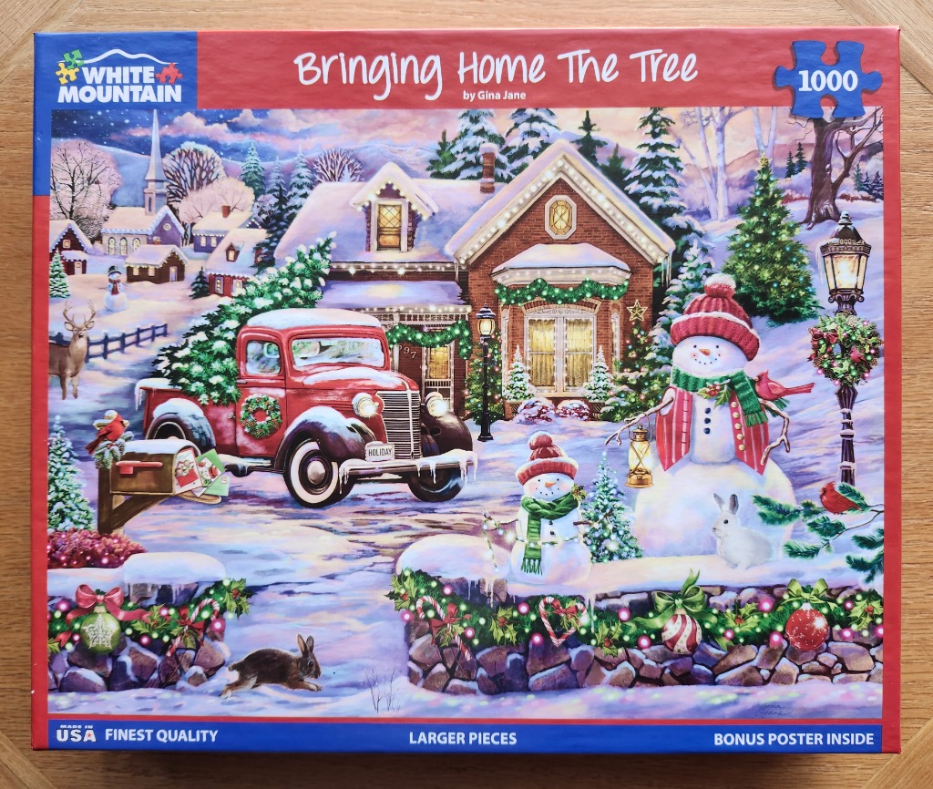 A festive winter scene with a red vintage truck, a brick house, and snowmen in a snowy landscape.