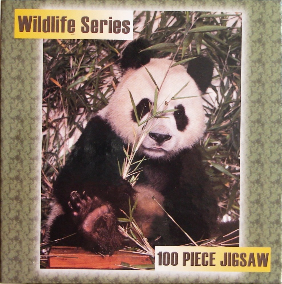A photograph of a giant panda sitting amidst bamboo stalks.