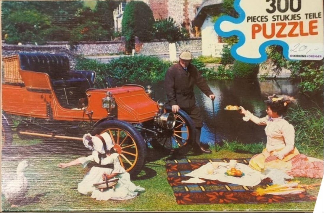 A vintage scene featuring an Edwardian-era motorcar, a man in a deerstalker hat, and a family picnicking by a pond.