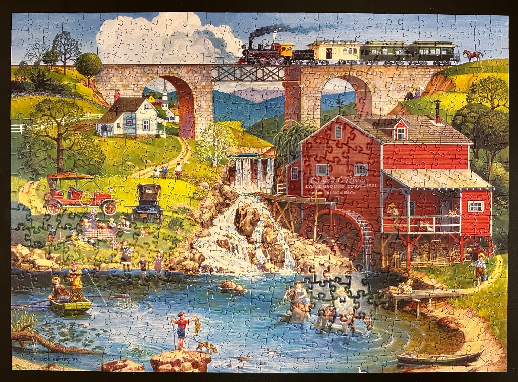 A nostalgic rural scene featuring a red mill, a stone bridge with a steam train, and people picnicking by a river.