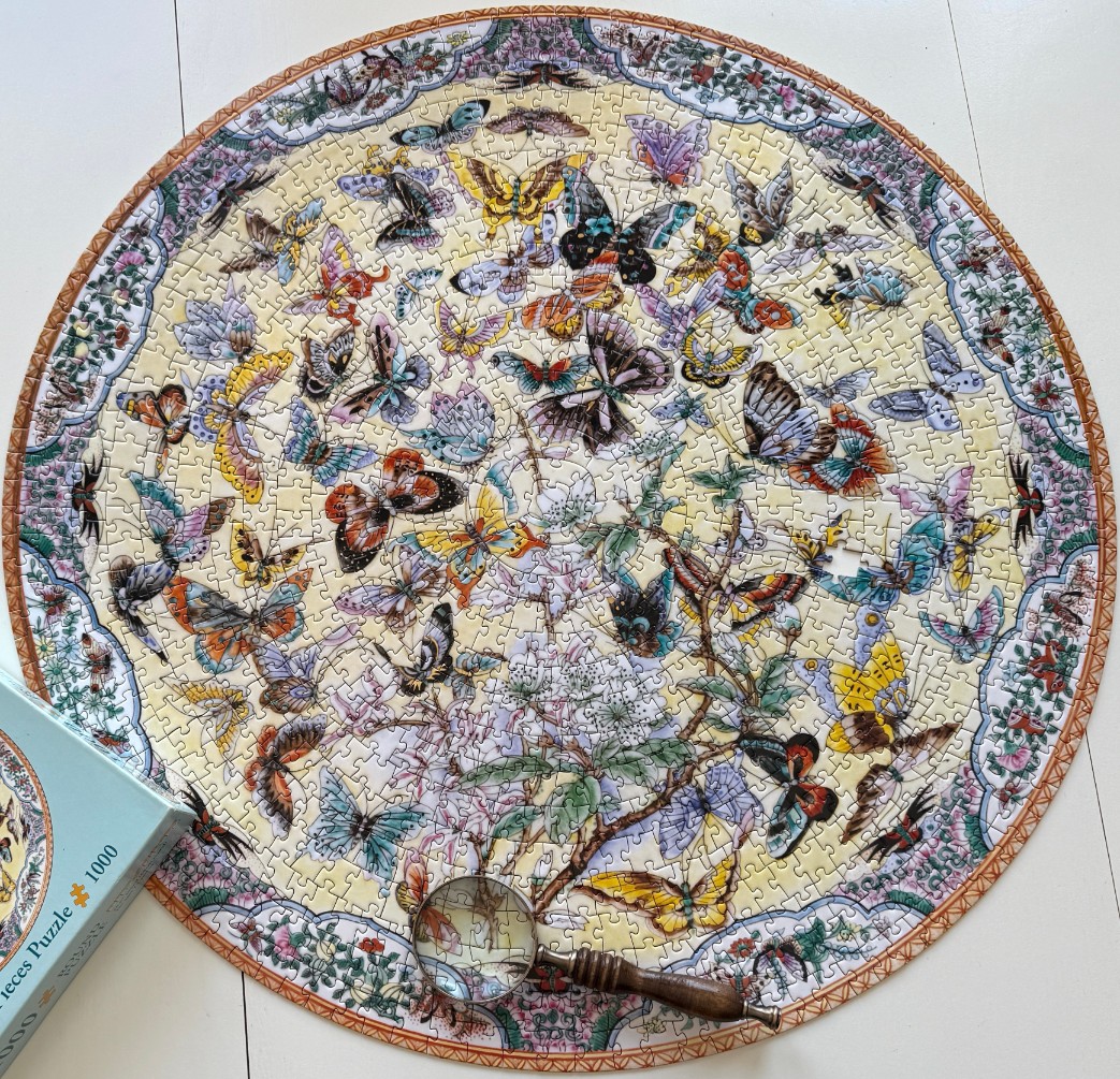 A circular illustration of a swarm of colorful butterflies around a flowering tree branch
