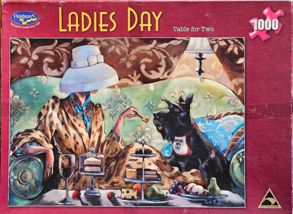 A stylish woman in a leopard print coat shares a snack with a Scottish Terrier on a blue sofa.