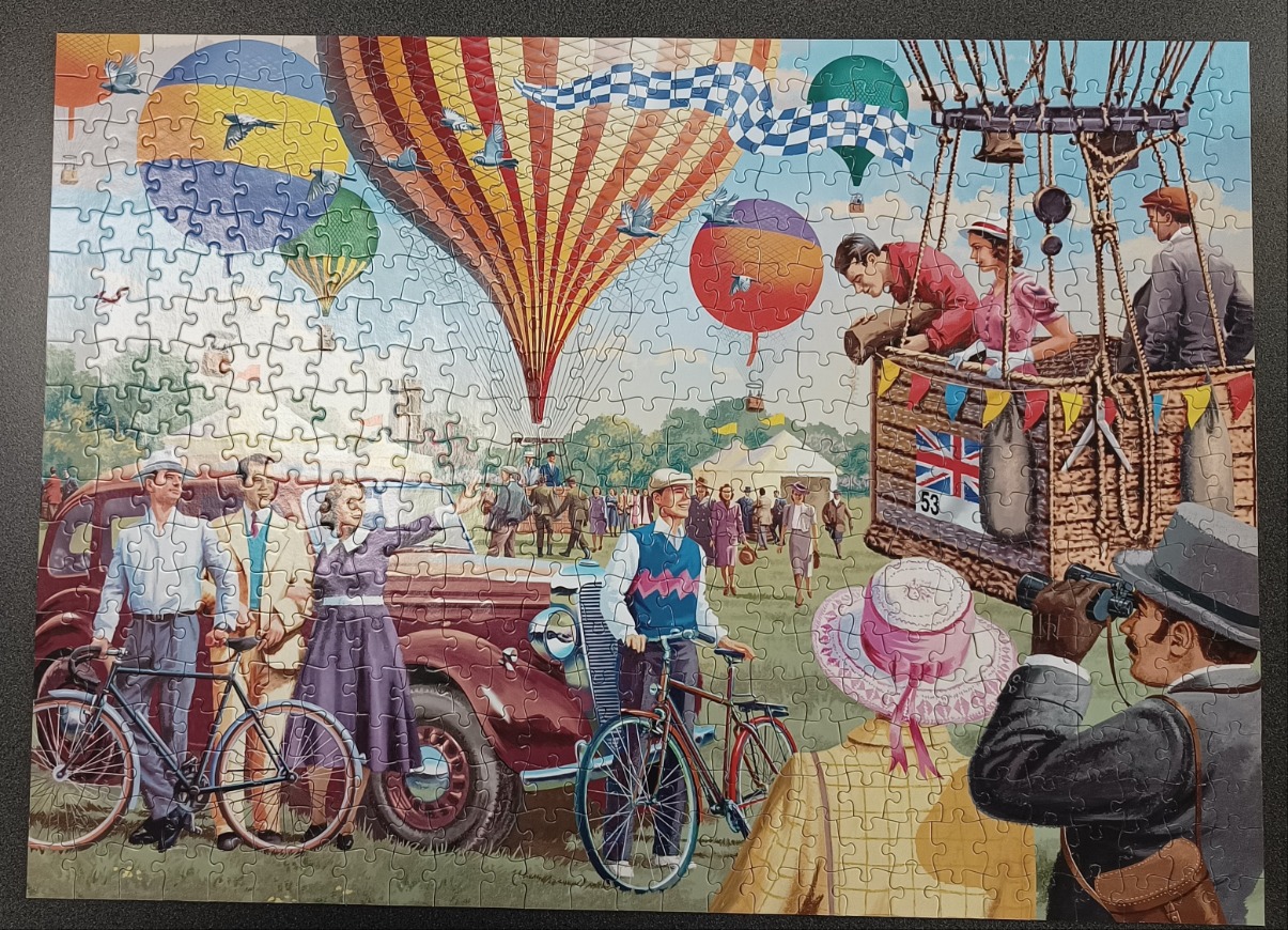 A 1950s-style illustration of people gathered at a colorful hot air balloon festival in a grassy park.