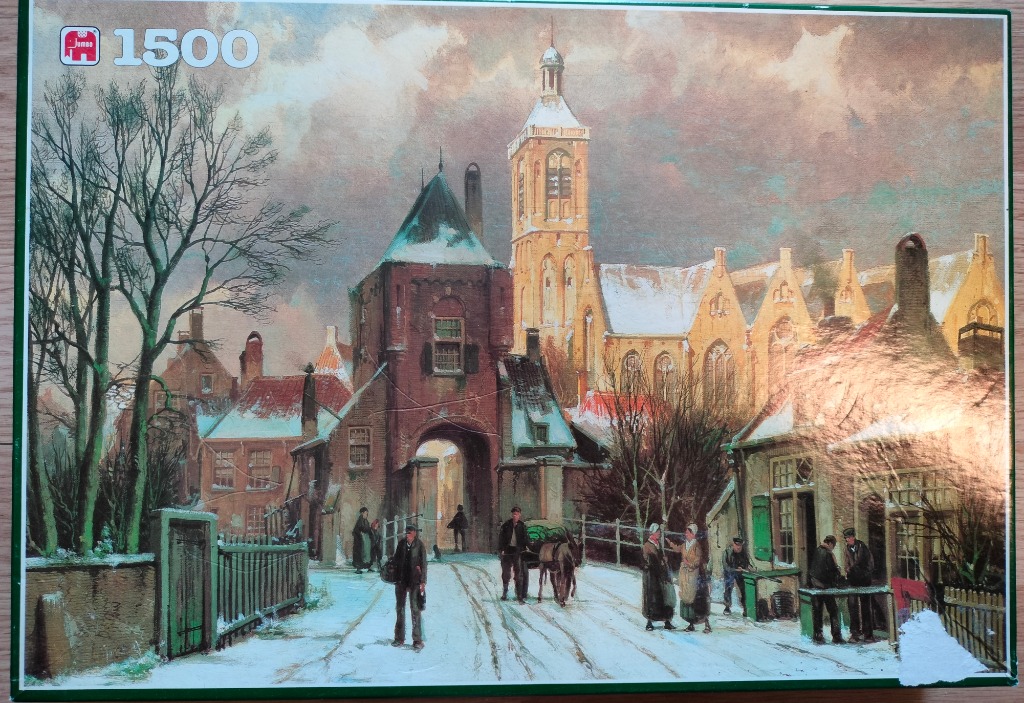 A wintry European village scene with a church and stone gate under a cloudy sky.
