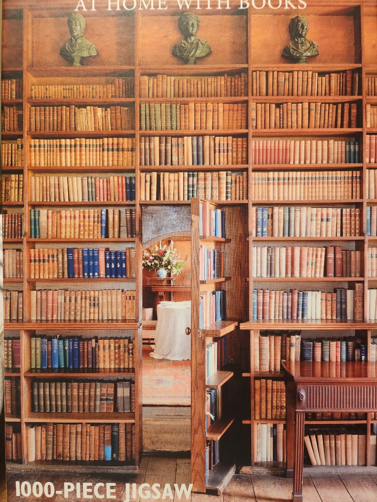 A secret door concealed within a floor-to-ceiling wooden library wall filled with antique books.