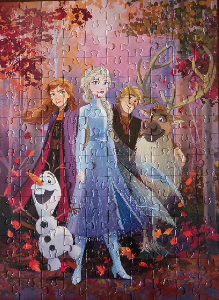 Animated characters Anna, Elsa, Kristoff, Sven, and Olaf in an autumn forest scene.