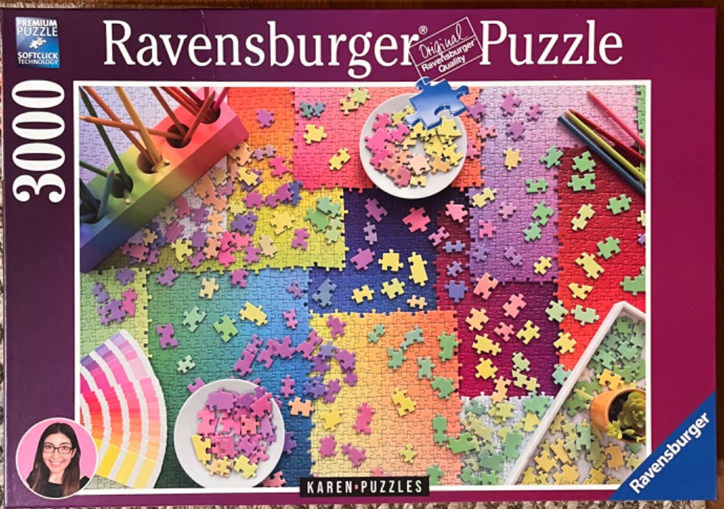 An overhead view of a rainbow-colored jigsaw puzzle in progress with matching pieces scattered on surface.