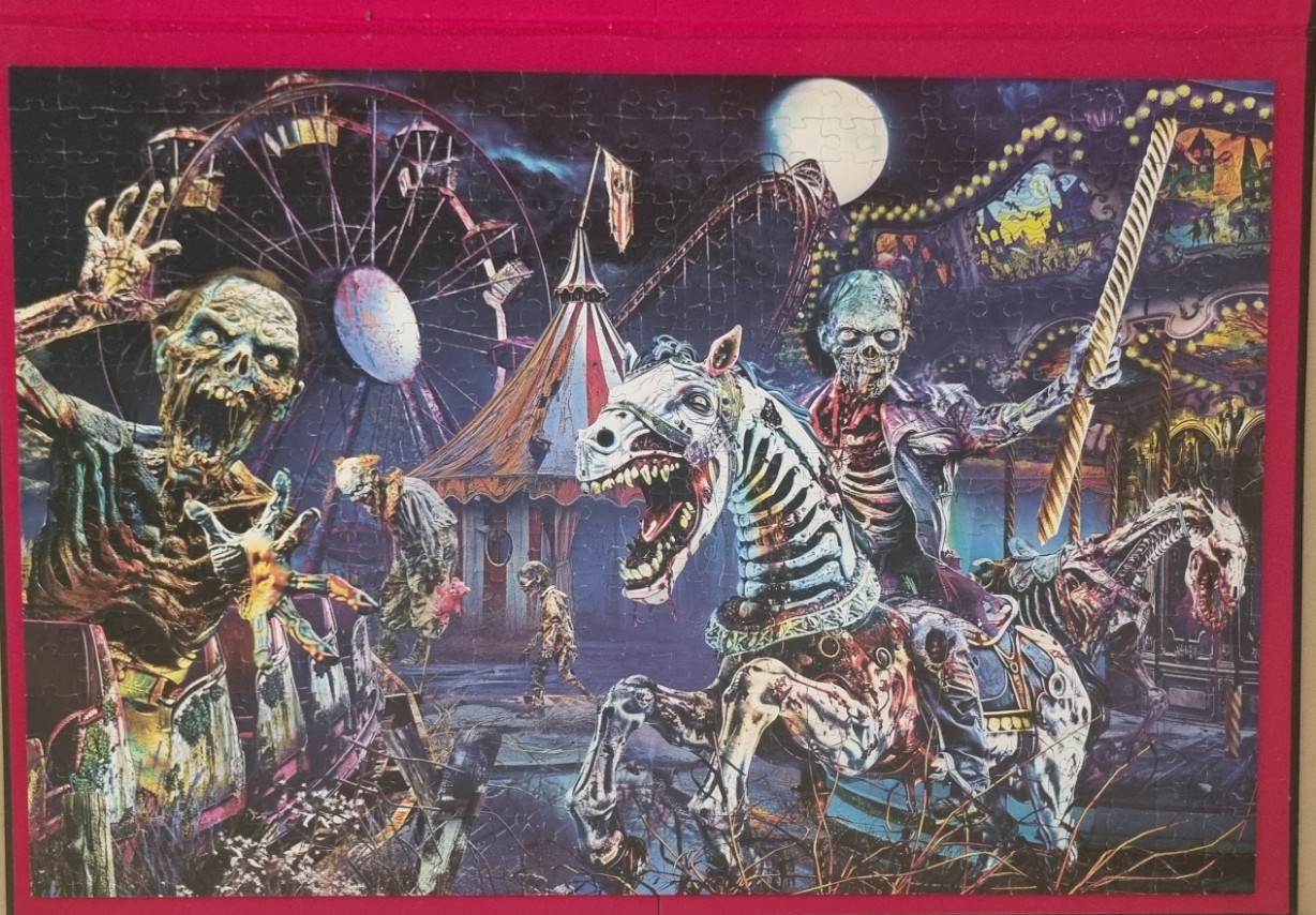 A nightmarish carnival scene featuring zombies riding a carousel and a looming Ferris wheel under a full moon.