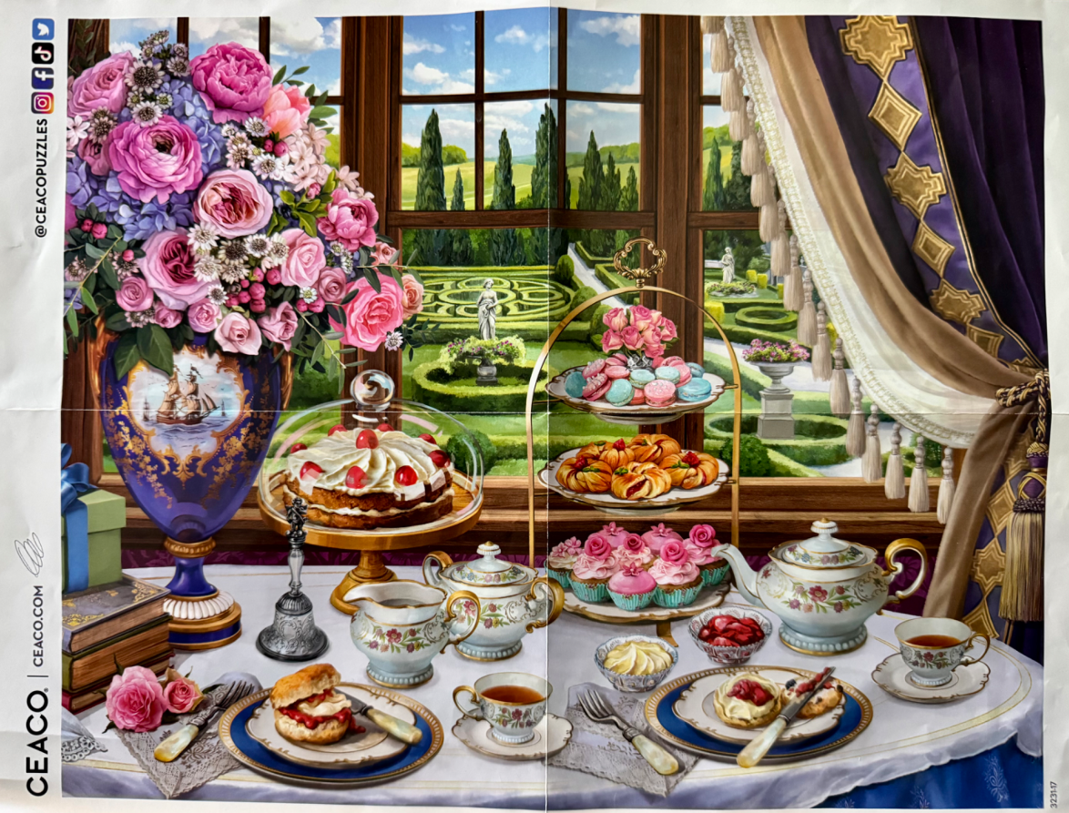 An elegant tea party table set with treats, a floral vase, and china in front of a garden window view.