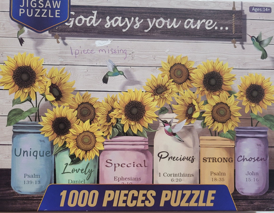 Bright sunflowers in colorful mason jars with hummingbirds against a wooden backdrop.