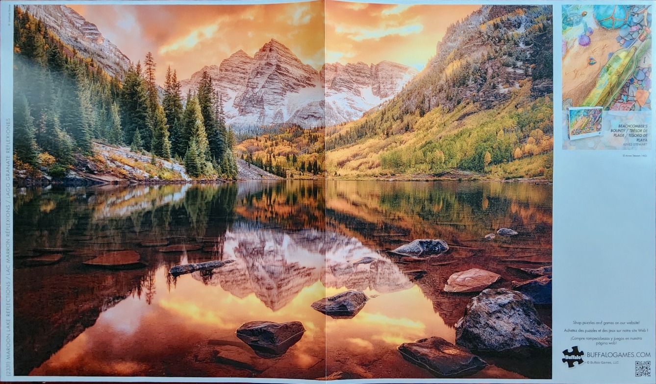 Maroon Bells mountain peaks reflected in a glassy alpine lake at sunset.