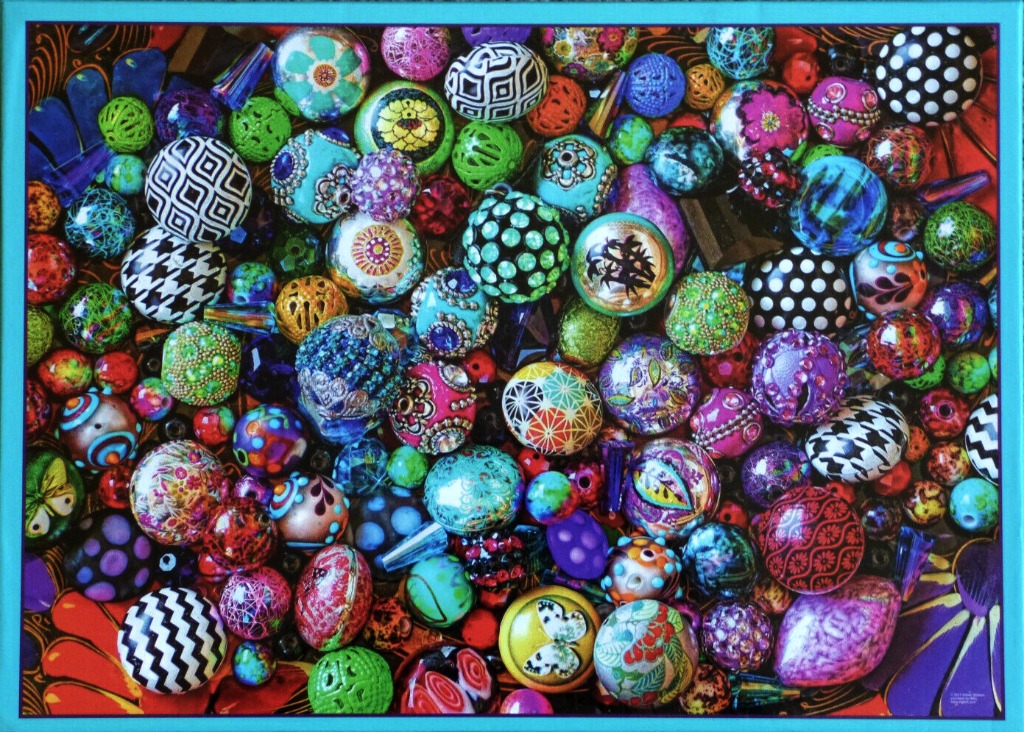 A dense, vibrant collection of multi-coloured, patterned, and textured decorative beads in various shapes and sizes.