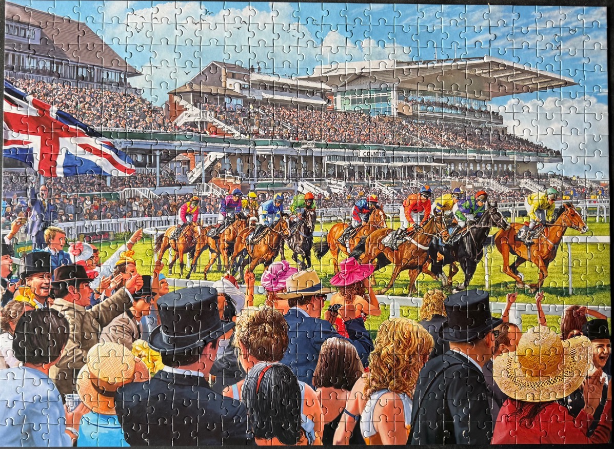 A lively scene at a British horse race with spectators in formal wear watching a field of thoroughbreds galloping past.