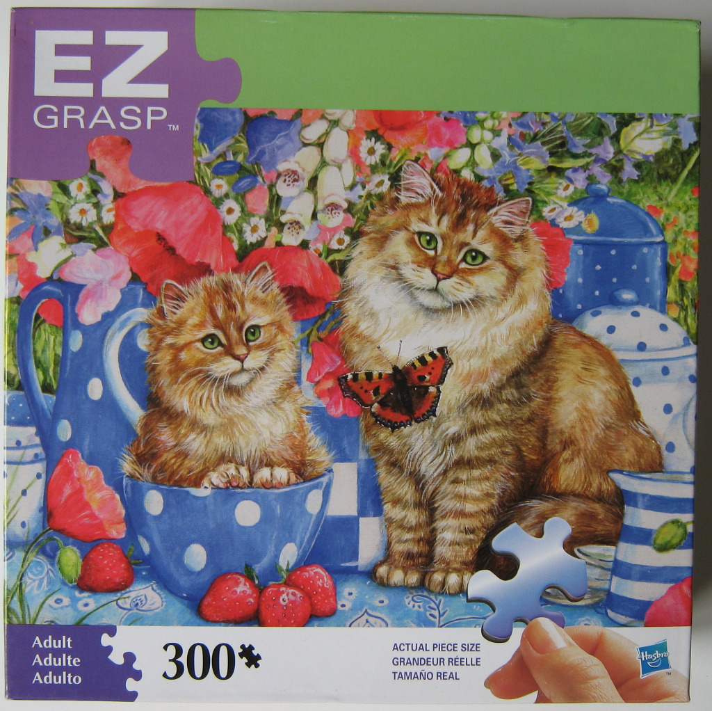 An illustration of a fluffy cat and kitten sitting among blue polka-dot kitchenware, vibrant poppies, and fresh strawberries.