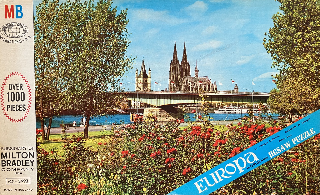 The Cologne Cathedral viewed across the Rhine River from a rose garden.