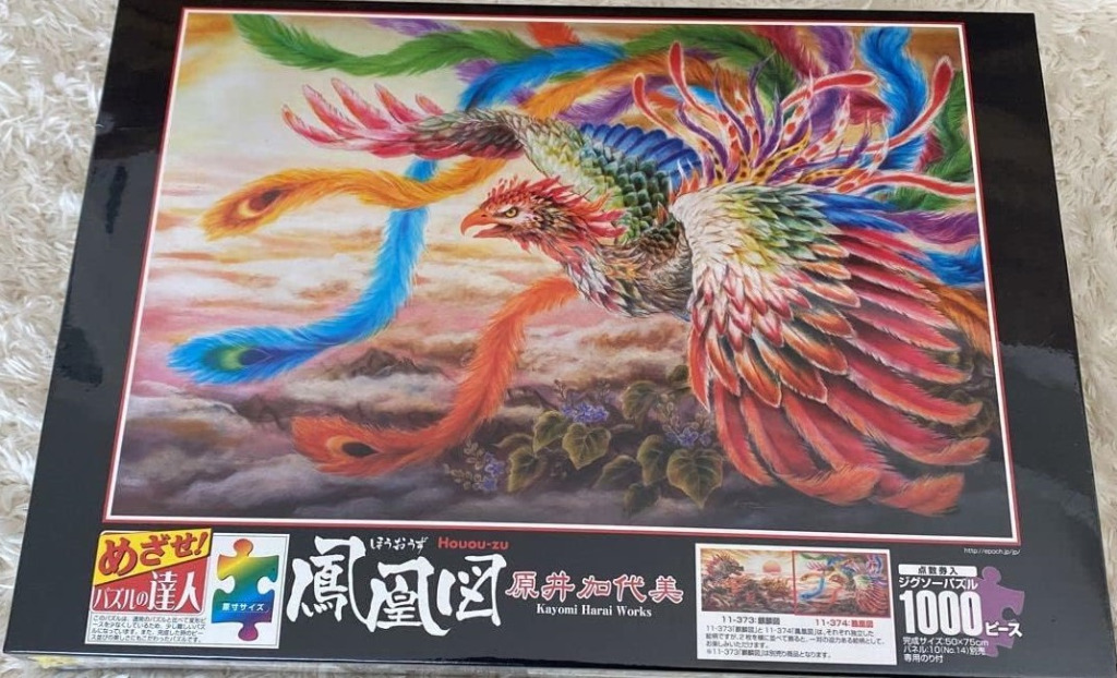 A vibrant digital painting of a phoenix with multicolored, trailing feathers flying over a misty mountain landscape.