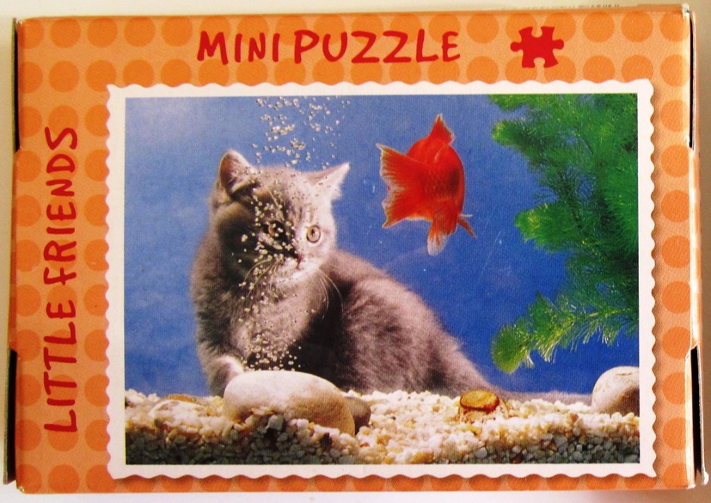 A grey kitten sitting underwater in an aquarium with a goldfish and green plants.
