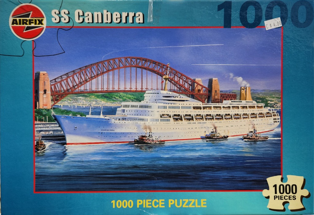The SS Canberra cruise ship sailing in front of the Sydney Harbour Bridge.
