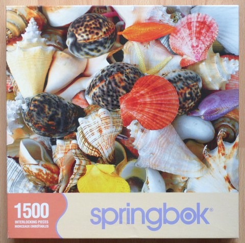 A close-up photograph of an assortment of colorful seashells and starfish piled together.