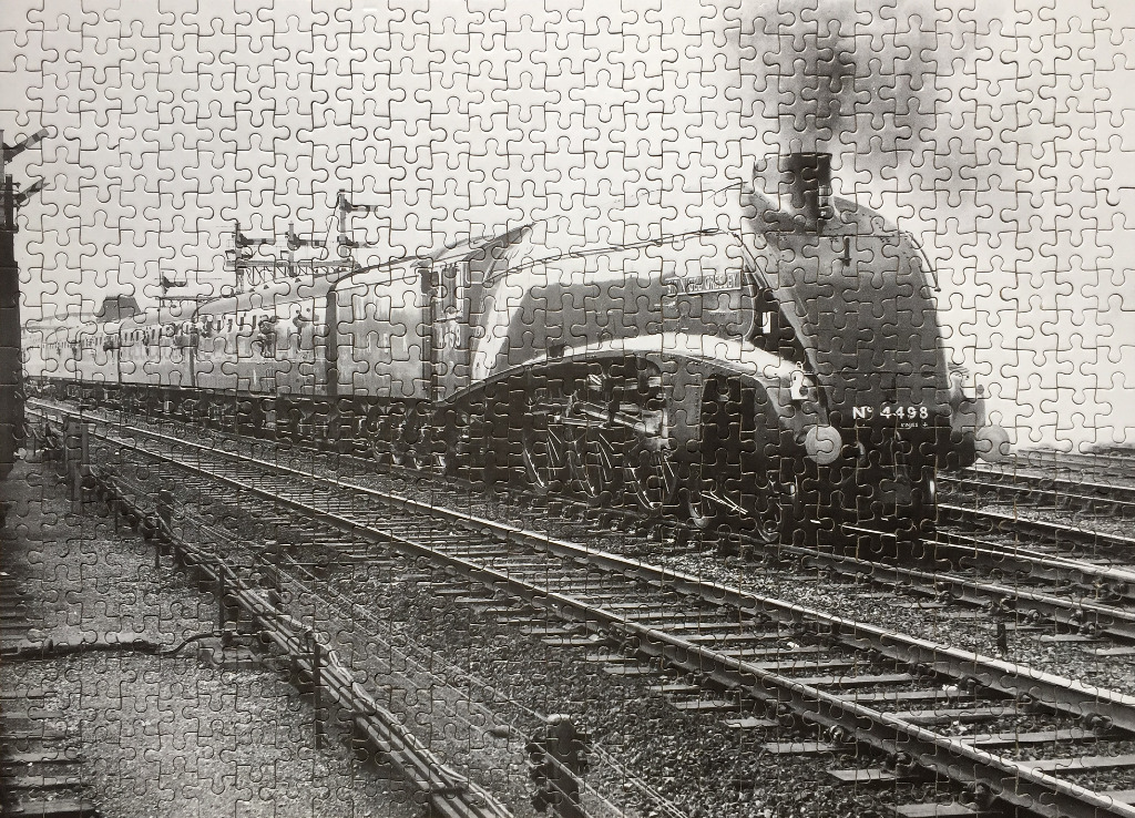 A vintage black and white photograph of the streamlined steam locomotive Sir Nigel Gresley No. 4498 pulling carriages.