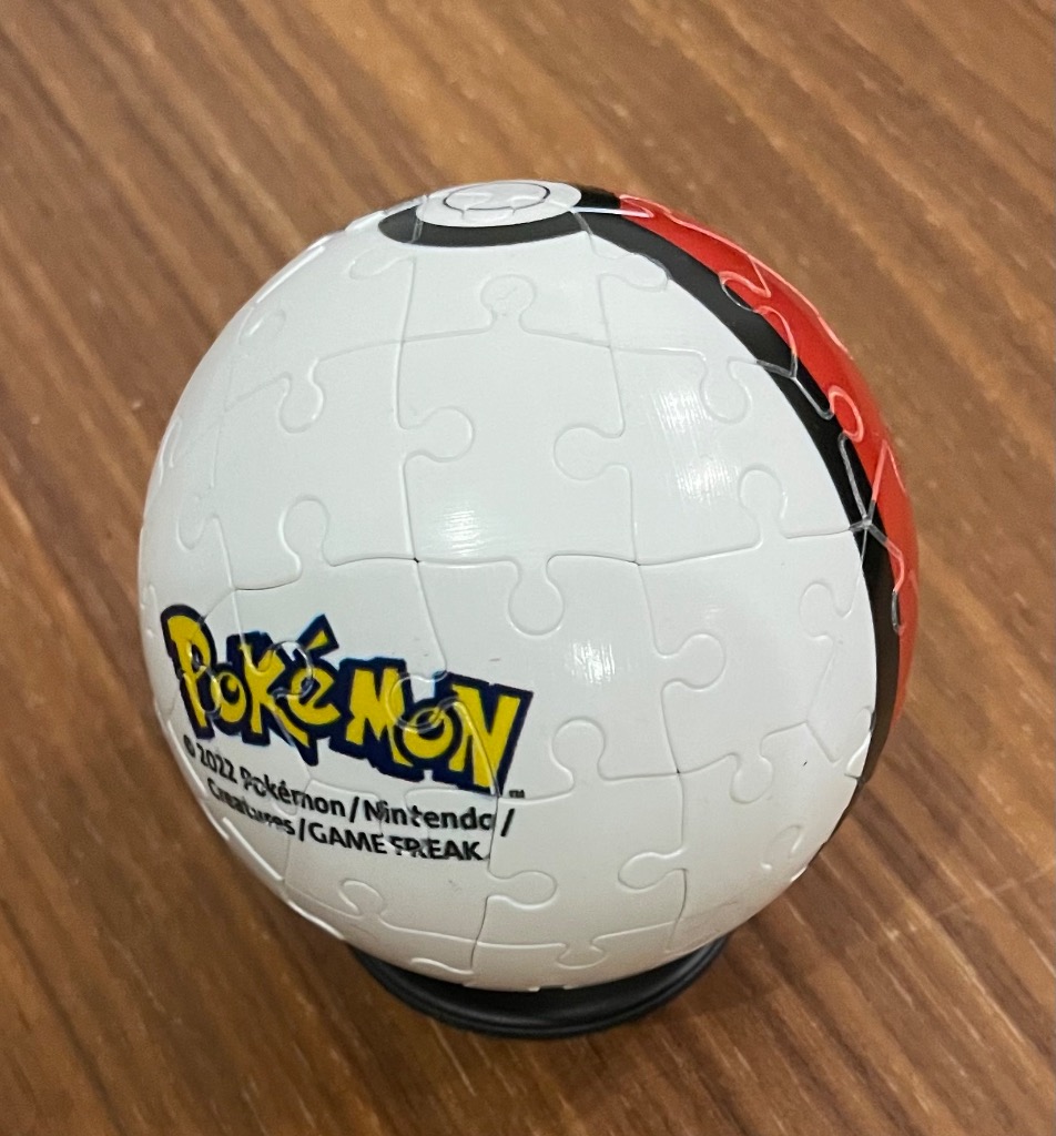 A spherical Poke Ball model with a white top, red bottom, and black band, featuring the Pokemon logo.