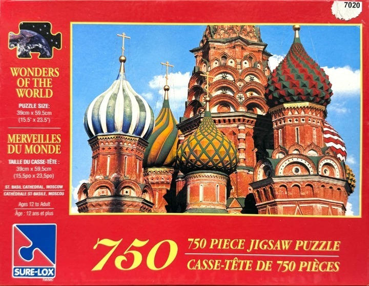 Low angle view of the colorful, onion-shaped domes of St. Basil's Cathedral in Moscow against a bright blue sky.