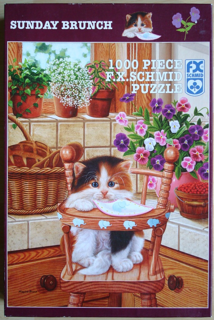 A fluffy calico kitten sits in a wooden high chair in a sunny kitchen window with plants and flowers.