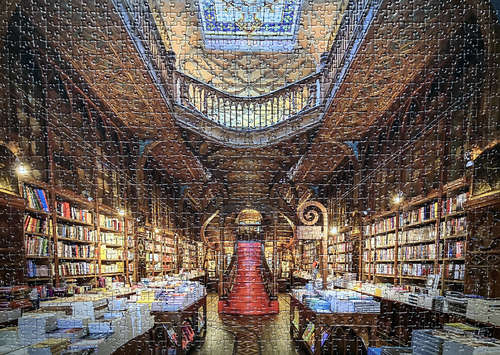 A symmetric view of the historic Livraria Lello bookstore in Porto with its iconic red staircase and wooden shelving.