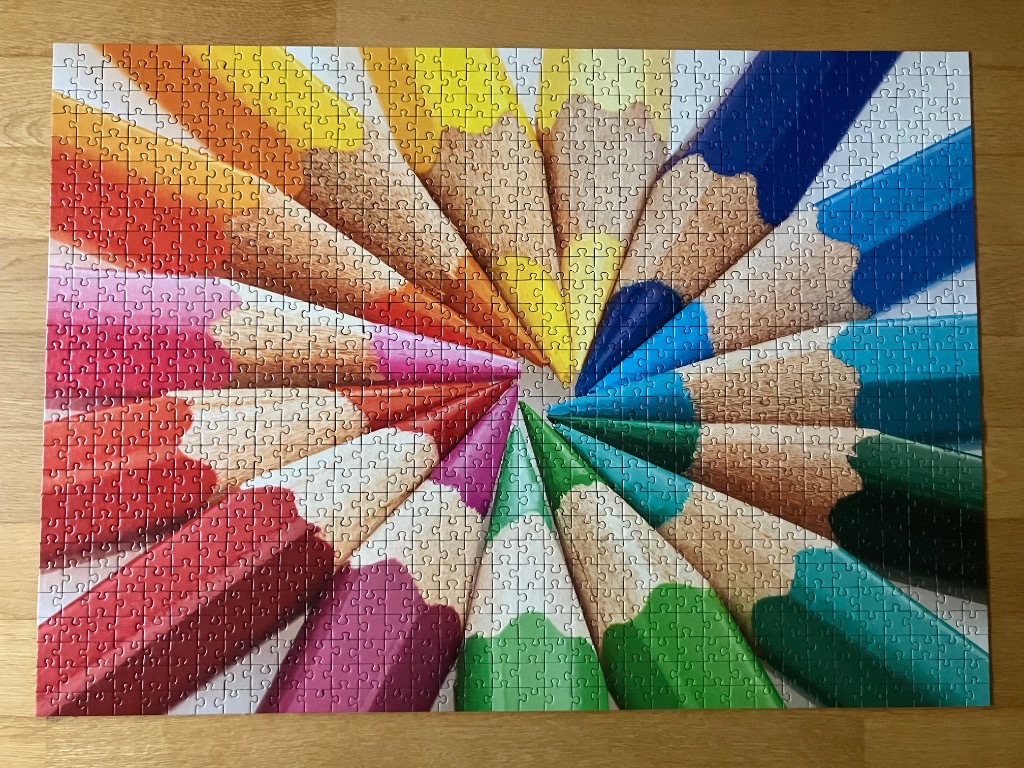 A radial arrangement of colorful sharpened pencils pointing toward a central point.
