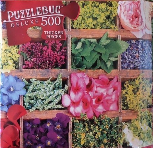 A wooden sorting tray filled with a variety of colorful flowers and green herbs.