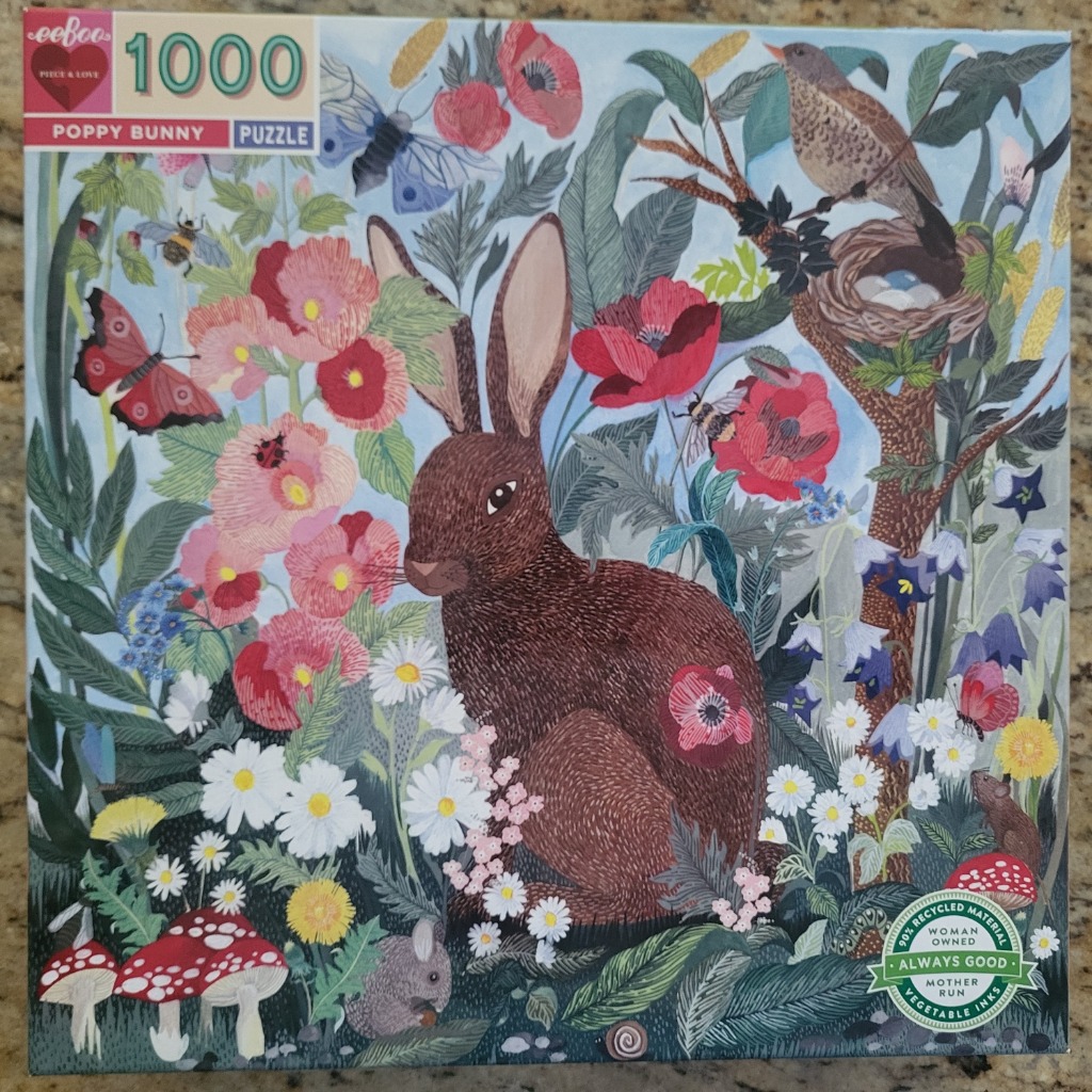 A brown rabbit sits in a vibrant meadow filled with red poppies, daisies, insects, and birds in a whimsical illustration.
