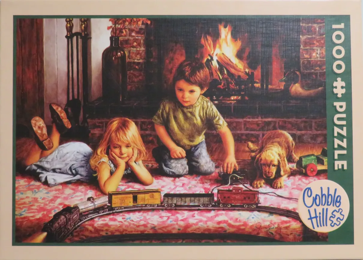 A boy and a girl playing with a toy train set on a rug in front of a warm fireplace.