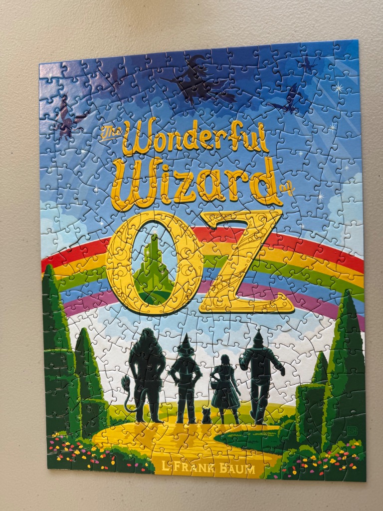 A whimsical illustration depicting the characters from The Wonderful Wizard of Oz walking toward the Emerald City.