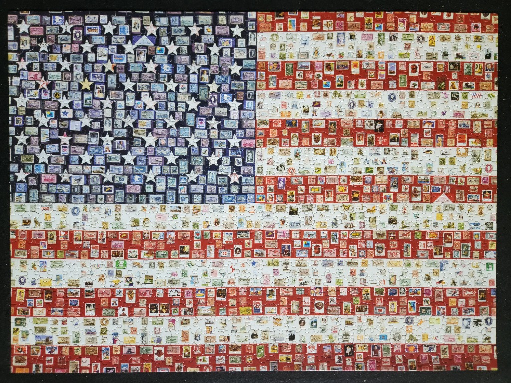 An American flag composed entirely of hundreds of miniature vintage postage stamps.