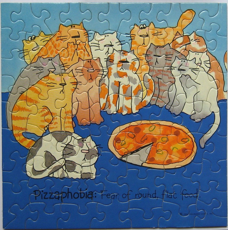 A cartoon illustration of ten cats huddled away from a pizza, with the text 'Pizzaphobia: Fear of round, flat food.'