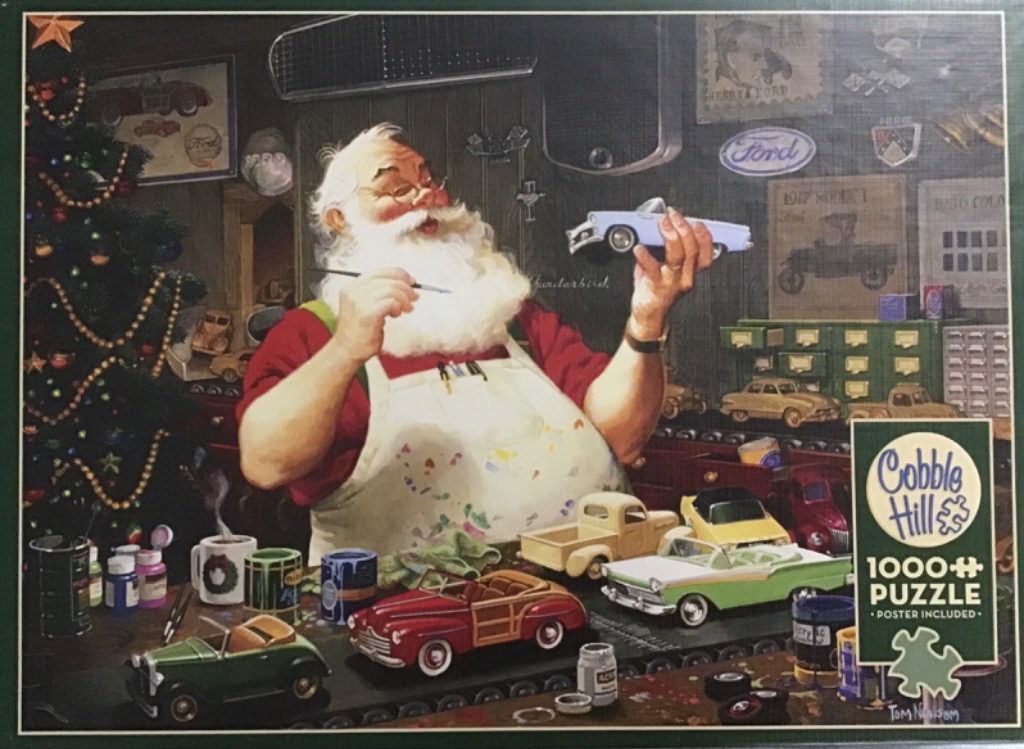 Santa Claus painting a toy car in his workshop filled with classic automobile collectibles.
