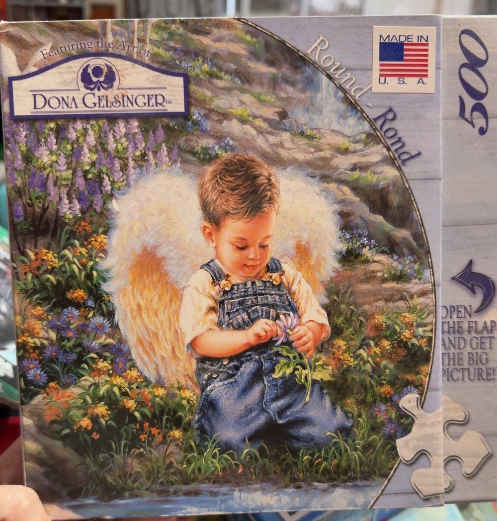 Painting of a toddler with angel wings sitting in a garden, holding a purple flower.