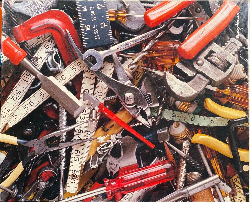 A dense, colorful collection of various vintage hand tools and measuring tapes piled together.