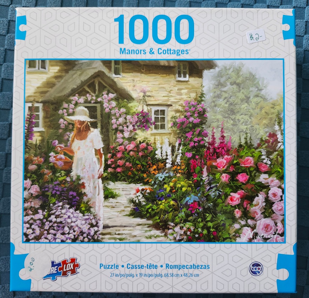 An oil painting of a woman in a white dress gardening in front of a stone cottage with a rose-covered entrance.