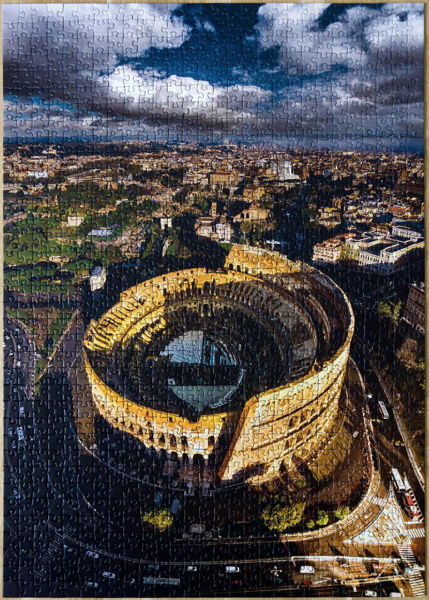 Aerial view of the Colosseum in Rome under a dramatic cloudy sky