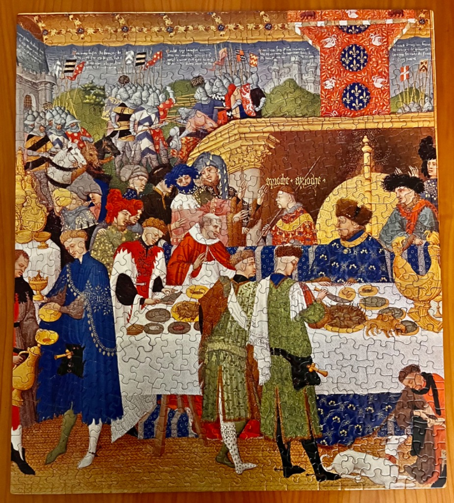 Medieval banquet scene featuring a royal feast with courtiers and soldiers in the background.