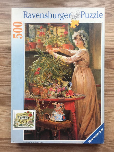 An oil painting of a young woman in a pink dress arranging flowers in a sunlit greenhouse.
