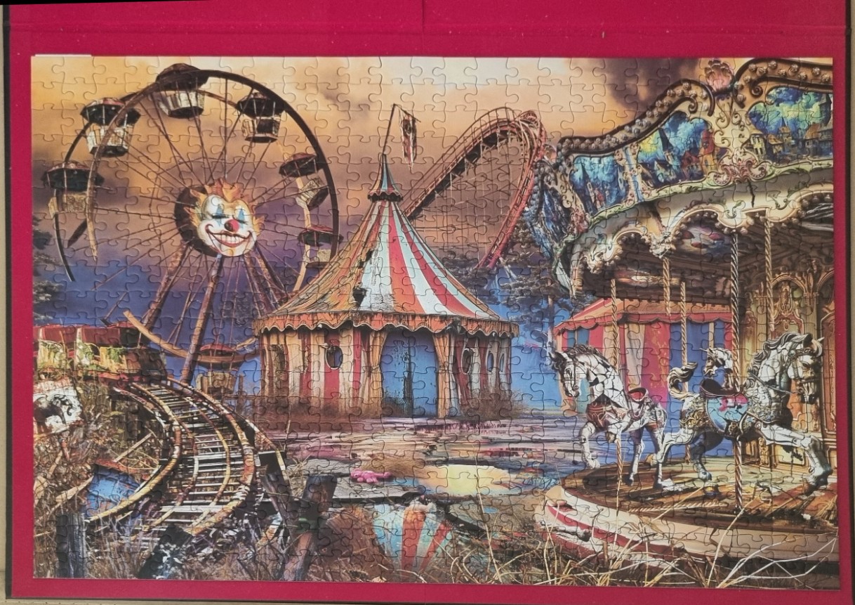 A spooky, abandoned carnival at twilight with a clown-faced ferris wheel, a carousel, and a dilapidated circus tent.
