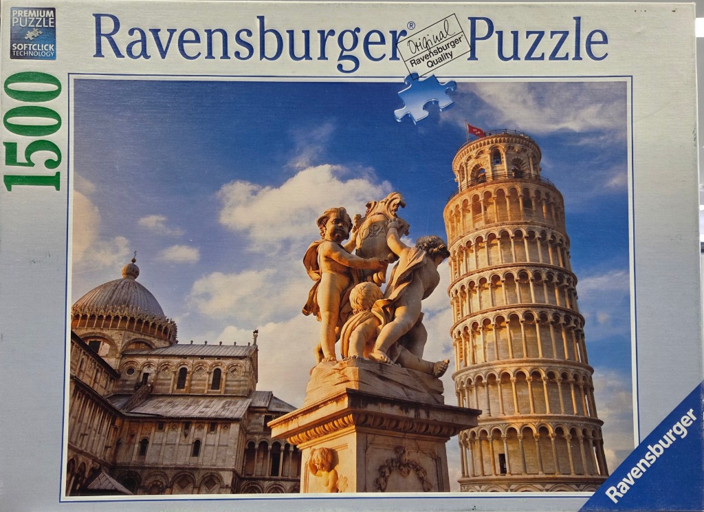 The Leaning Tower of Pisa and Pisa Cathedral viewed behind a stone sculpture of cherubs.