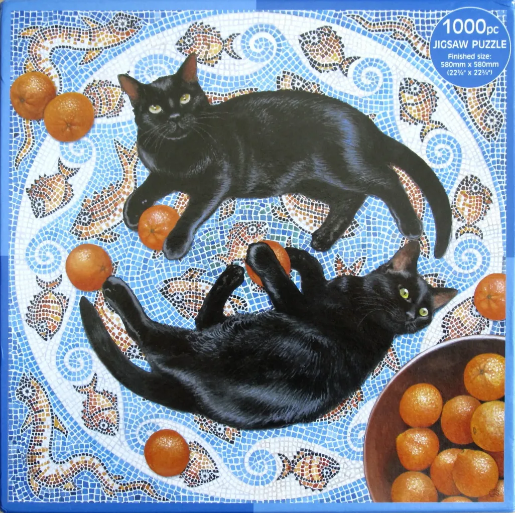 Two black cats lounging on a blue mosaic tile floor decorated with fish motifs and scattered oranges.