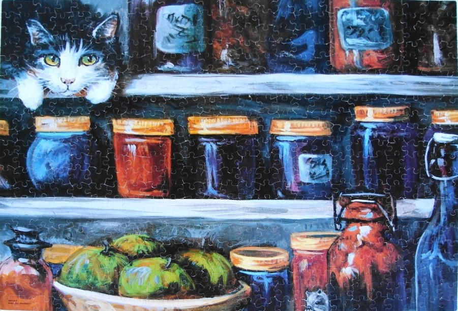 A black and white cat peeking over a kitchen shelf filled with jars and bowls of fruit.